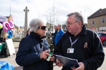 A woman speaking to a man with a clipboard