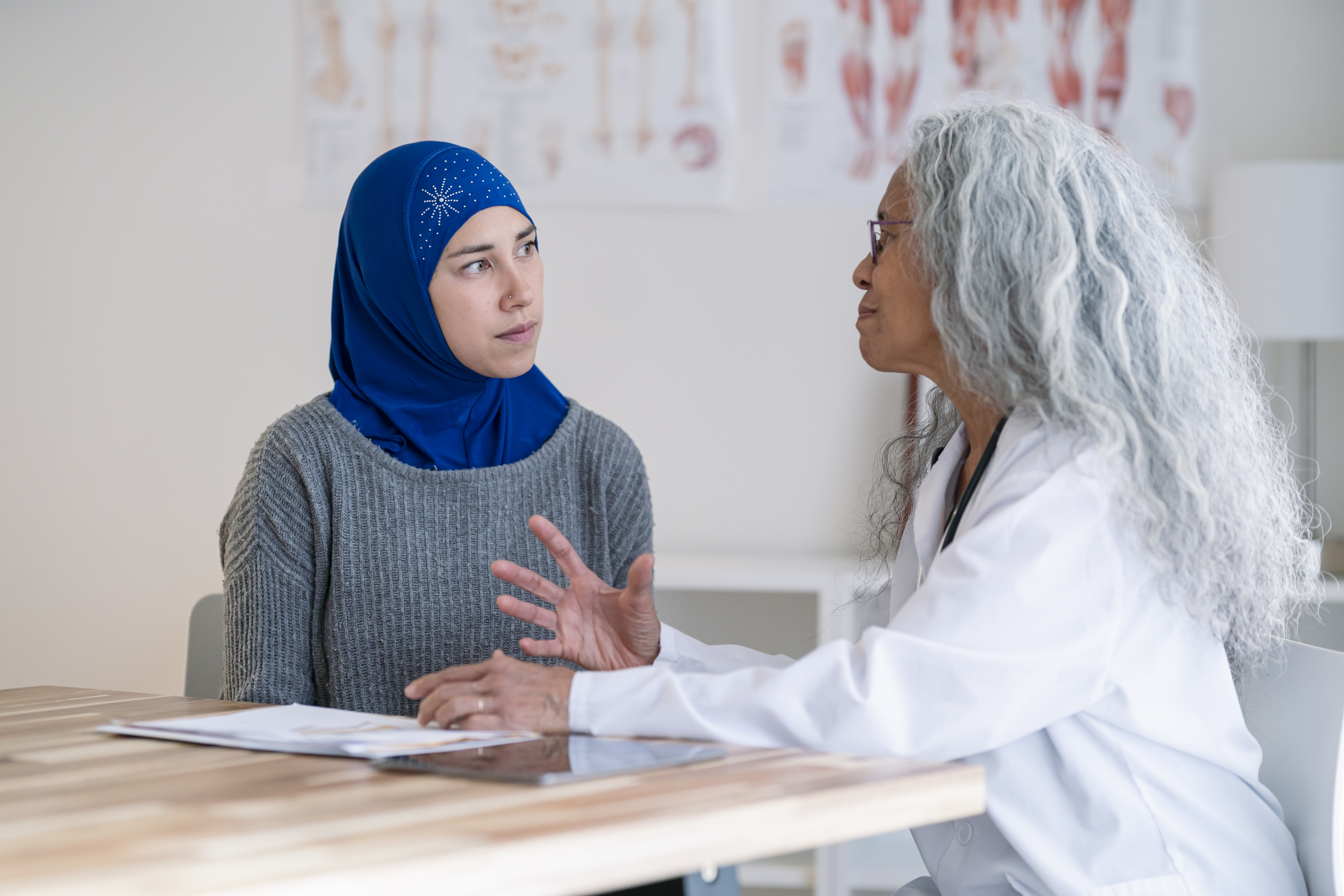 Muslim woman wearing a hijab is having a wellness check with her primary care doctor
