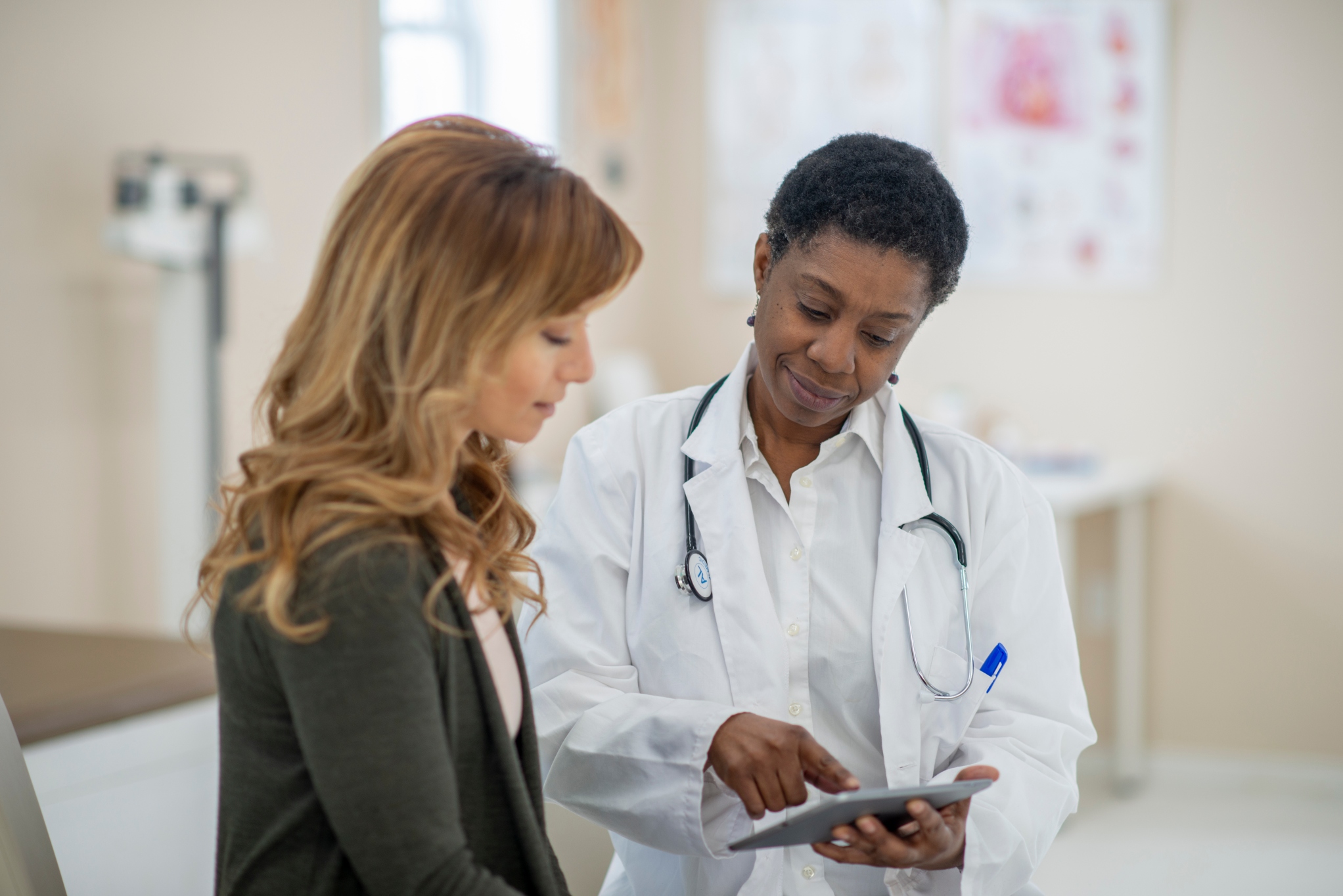 woman in exam room looking at results with doctor