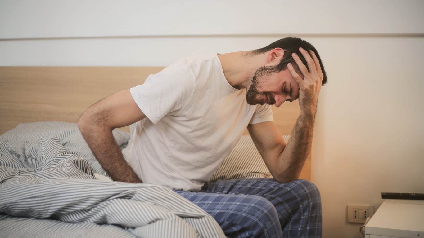 A young man in pain as he tried to get out of bed