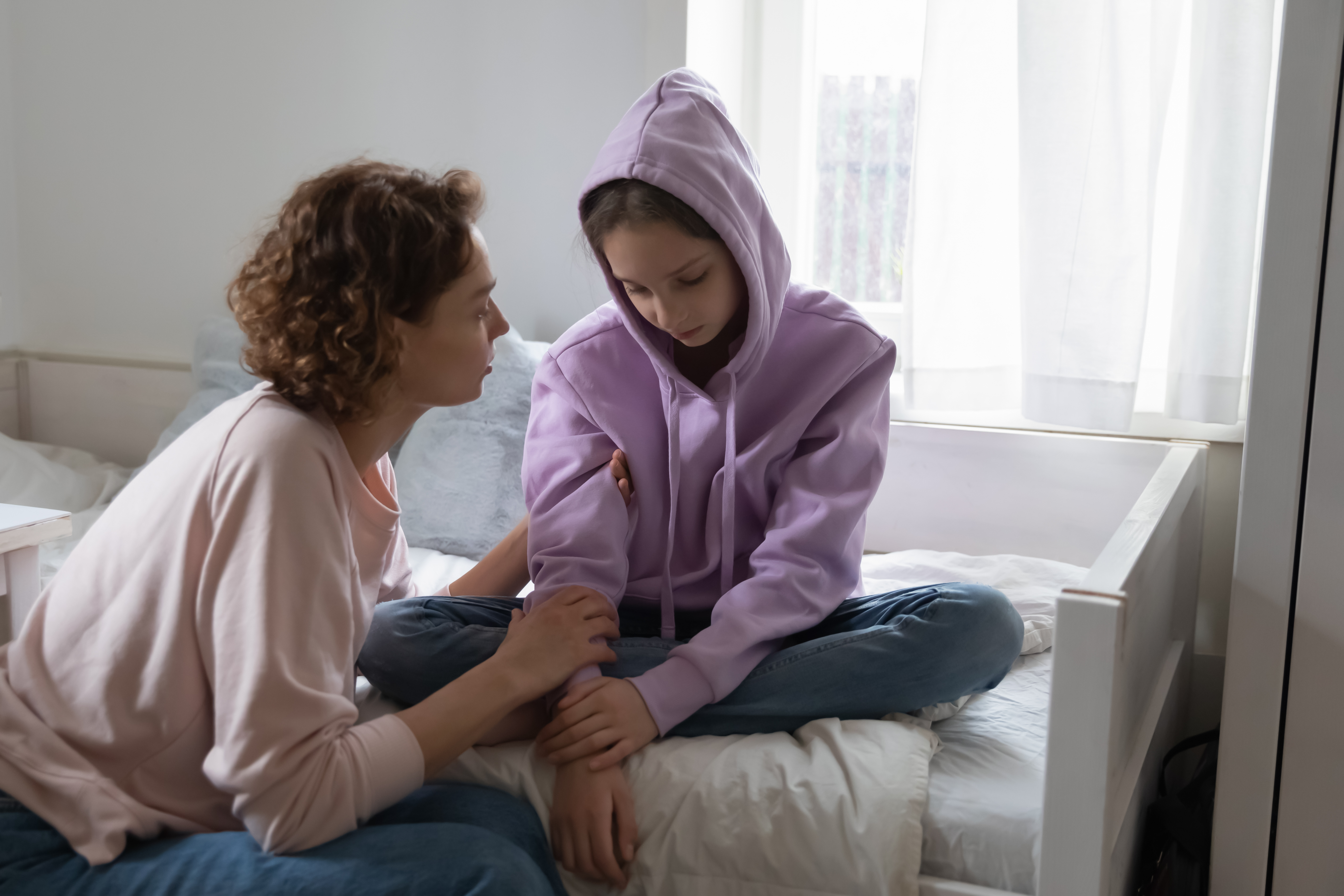 Affectionate young mommy supporting stressed sad teen child daughter. Unhappy depressed adolescent kid girl suffering from personal problems or bullying at school, sharing difficulties with mum.