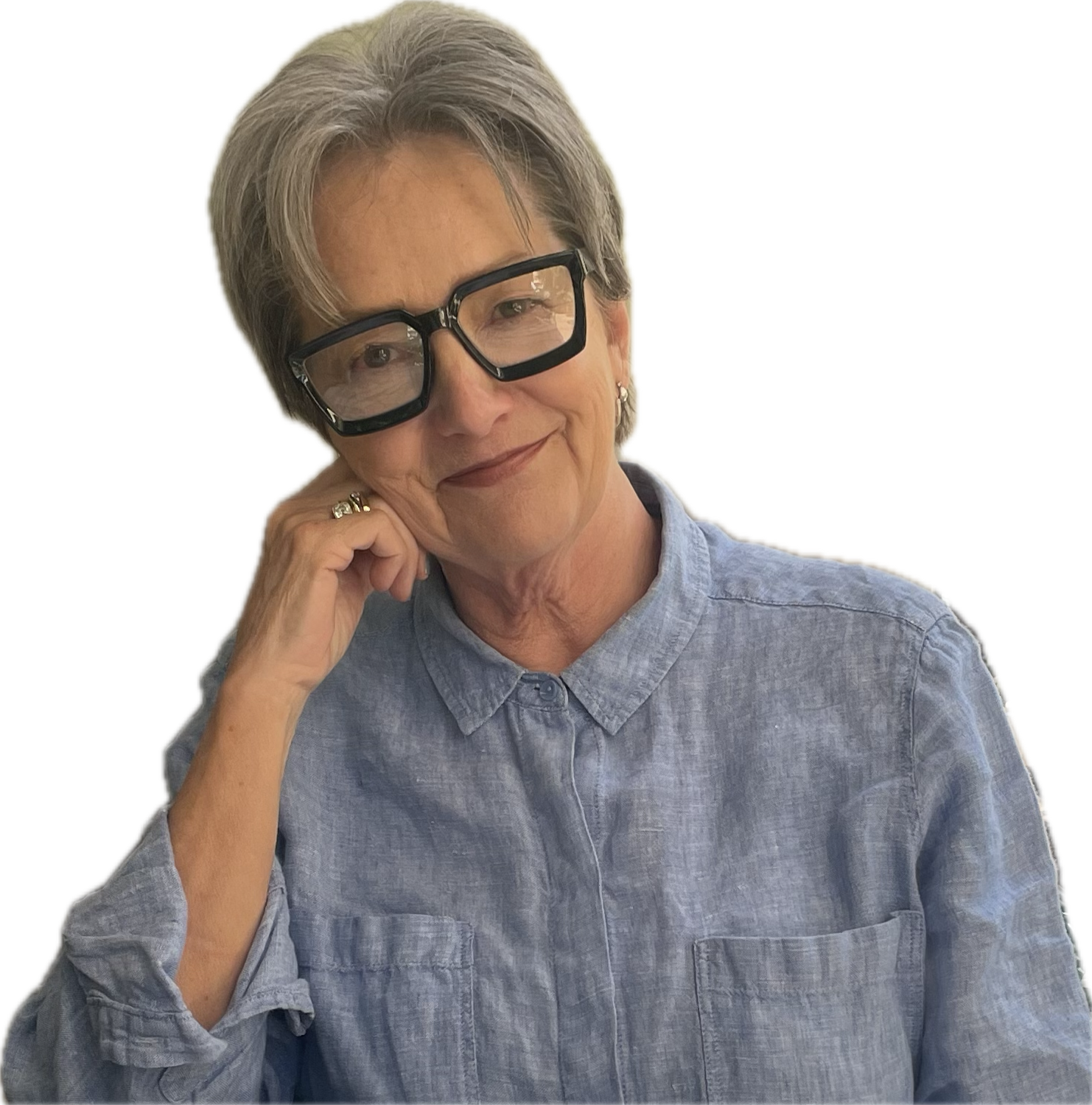 Stephanie, a White woman, grey hair, wearing glasses and staring into camera, smiling