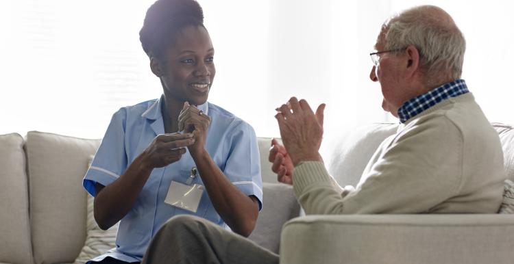 Nurse communicates using sign language with elderly gentleman