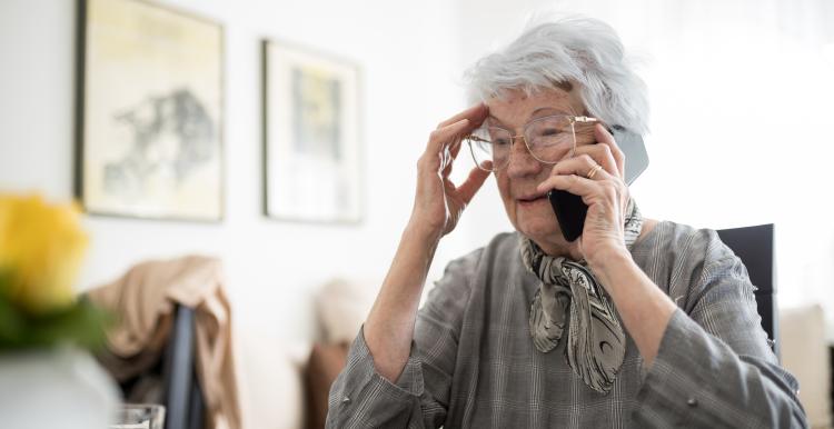 Sad and lonely senior gray-haired Caucasian woman talking on the mobile phone, receiving bad news. Loneliness and aging concept