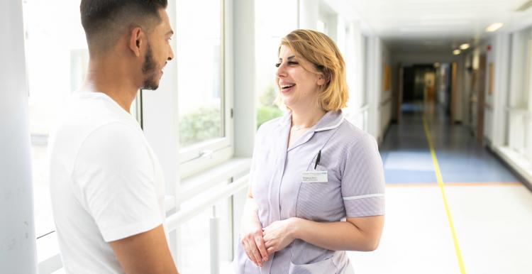  A young man talking to a nurse in a corridor