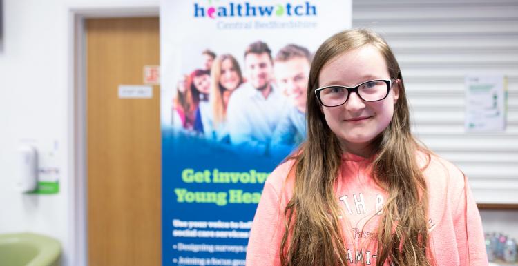 Young girl in front of Healthwatch sign