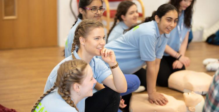 Teenage girls taking part in first aid session. 
