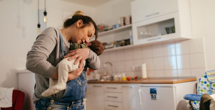 Woman holding baby in her kitchen