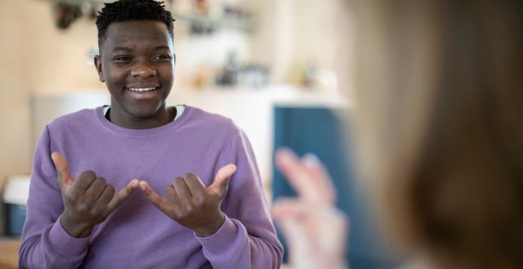 Teenage boy and girl having conversation using Sign Language