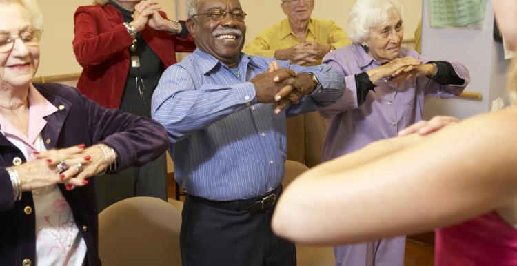 Elderly people in a care home doing group exercise