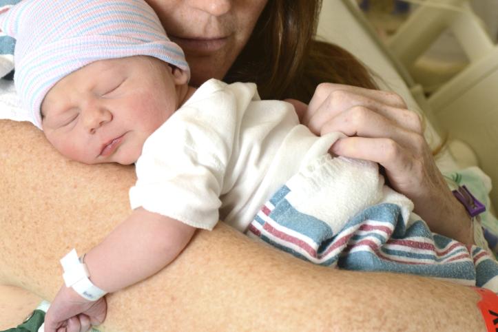 A mother holding her newborn in hospital
