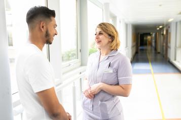 A nurse speaks to a patient in a hospital