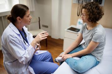 young woman with doctor in exam room
