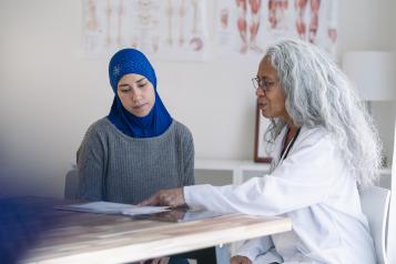 Muslim woman wearing a hijab attending a wellness check with her primary care doctor