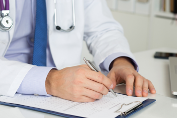 Healthcare professional writing a fit note