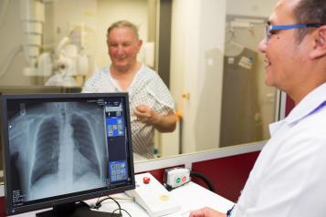 Radiographer helping a male patient