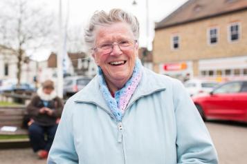 Elderly woman smiling at camera from community event