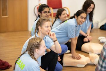 Teenage girls taking part in first aid session. 