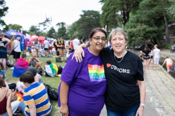 Two women at a pride demonstration with their arms around each other