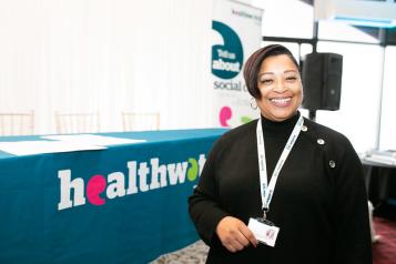 A women in front of a Healthwatch stand 