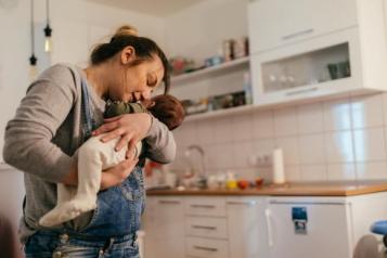 Women holding a baby in her kitchen