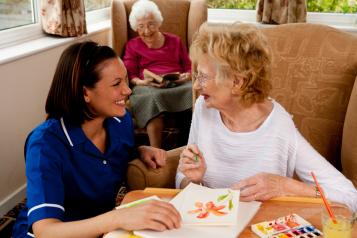 A nurse and an older woman talking and smiling