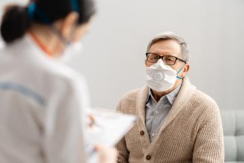 Doctor and senior man wearing facemasks during coronavirus outbreak.