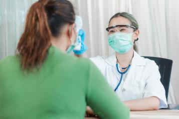Doctor and senior woman wearing facemasks during coronavirus pandemic.