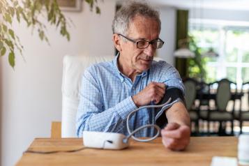 Man monitoring his blood pressure at home