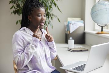 Teenage girl having conversation using Sign Language on laptop