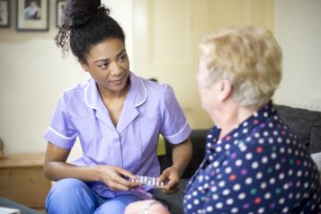 Social care worker speaking to a lady in her home