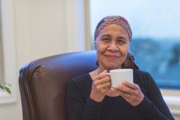 Woman wearing a headscarf holding a mug