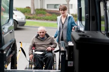 Older man in wheel chair with carer