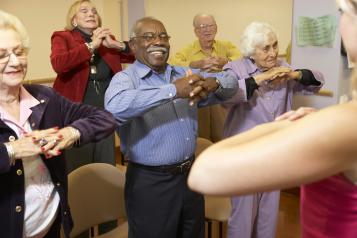 Elderly people in a care home doing group exercise