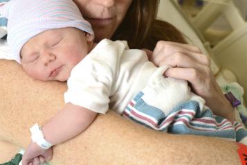 A mother holding her newborn in hospital A mother holding her newborn in hospital