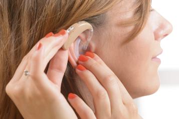  woman applying earing aid