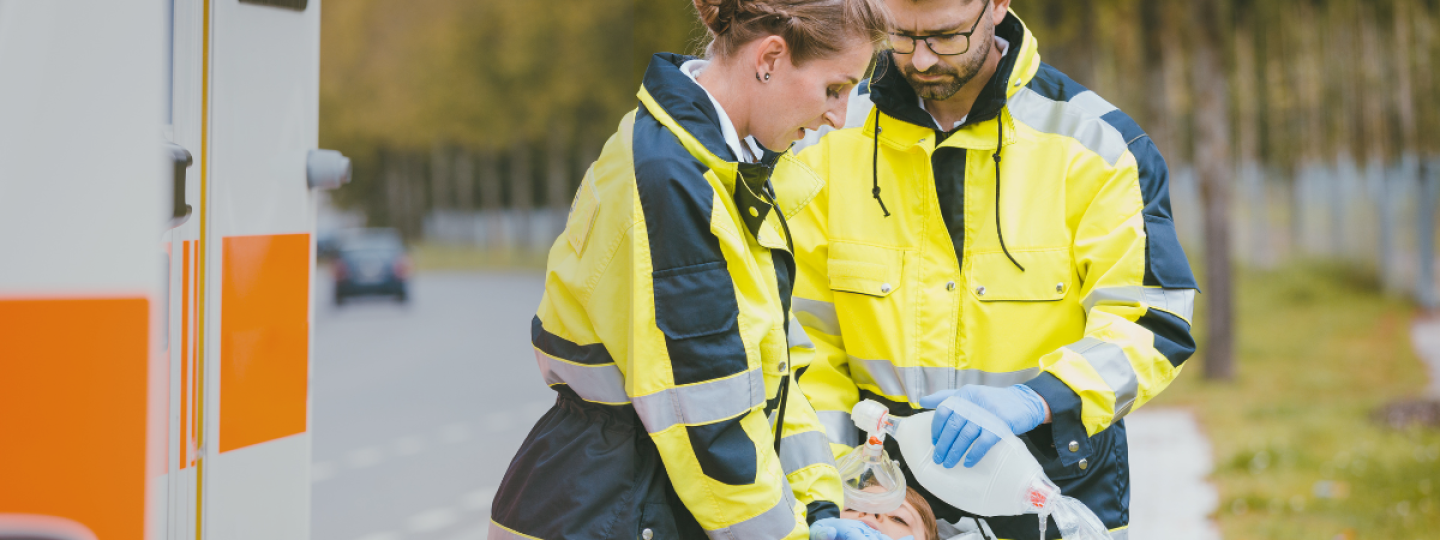 Two paramedics support a person on a stretcher